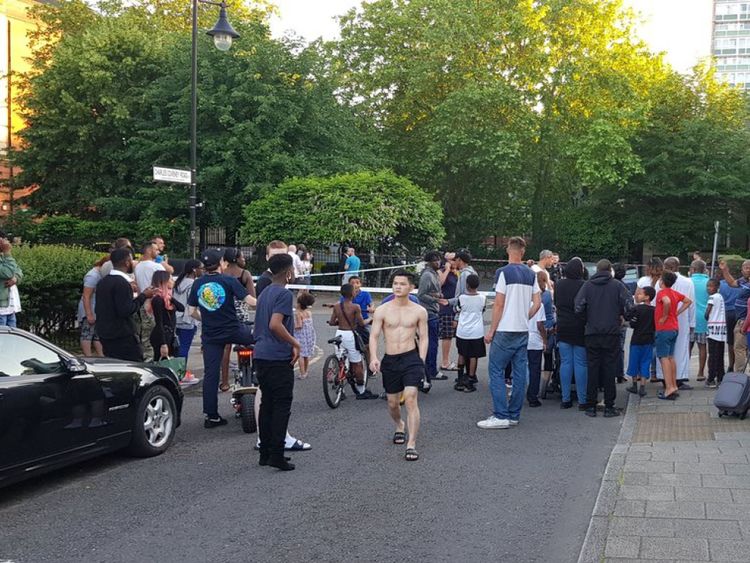 A large crowd gathered outside the cordon in Peckham