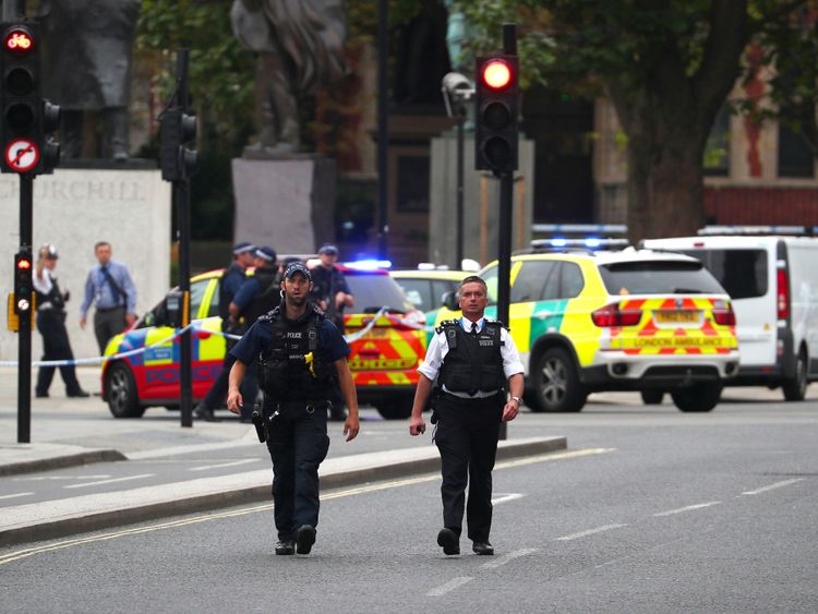 Police patrol the scene outside parliament where a car is said to have crashed