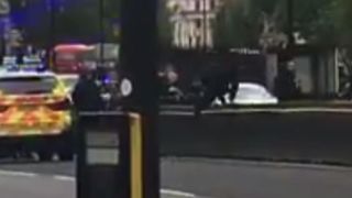 Armed police reach the scene of a crashed vehicle outside the Houses of Parliament