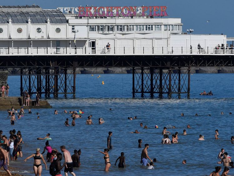 Beachgoers cool down in the sea during hot weather at Brighton in southern Britain, August 3, 2018. REUTERS/Toby Melville