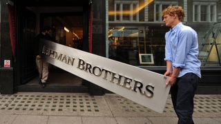 Employees pose for photographers with a Lehman Brothers company sign at Christie&#39;s auction house in London on September 24, 2010. The sign will be sold as part of the &#39;Lehman Brothers: Artwork and Ephemera&#39; sale in London on September 29. AFP PHOTO / BEN STANSALL (Photo credit should read BEN STANSALL/AFP/Getty Images)
